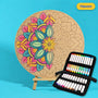 400mm Haven engraved circle art board with mandala of overlapping leaves, left half coloured pink, teal and yellow, beside a case of 24 Nahuku markers