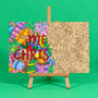 Merry Christmas engraved quote art board half coloured for inspiration and half plain uncoloured on easel on green background