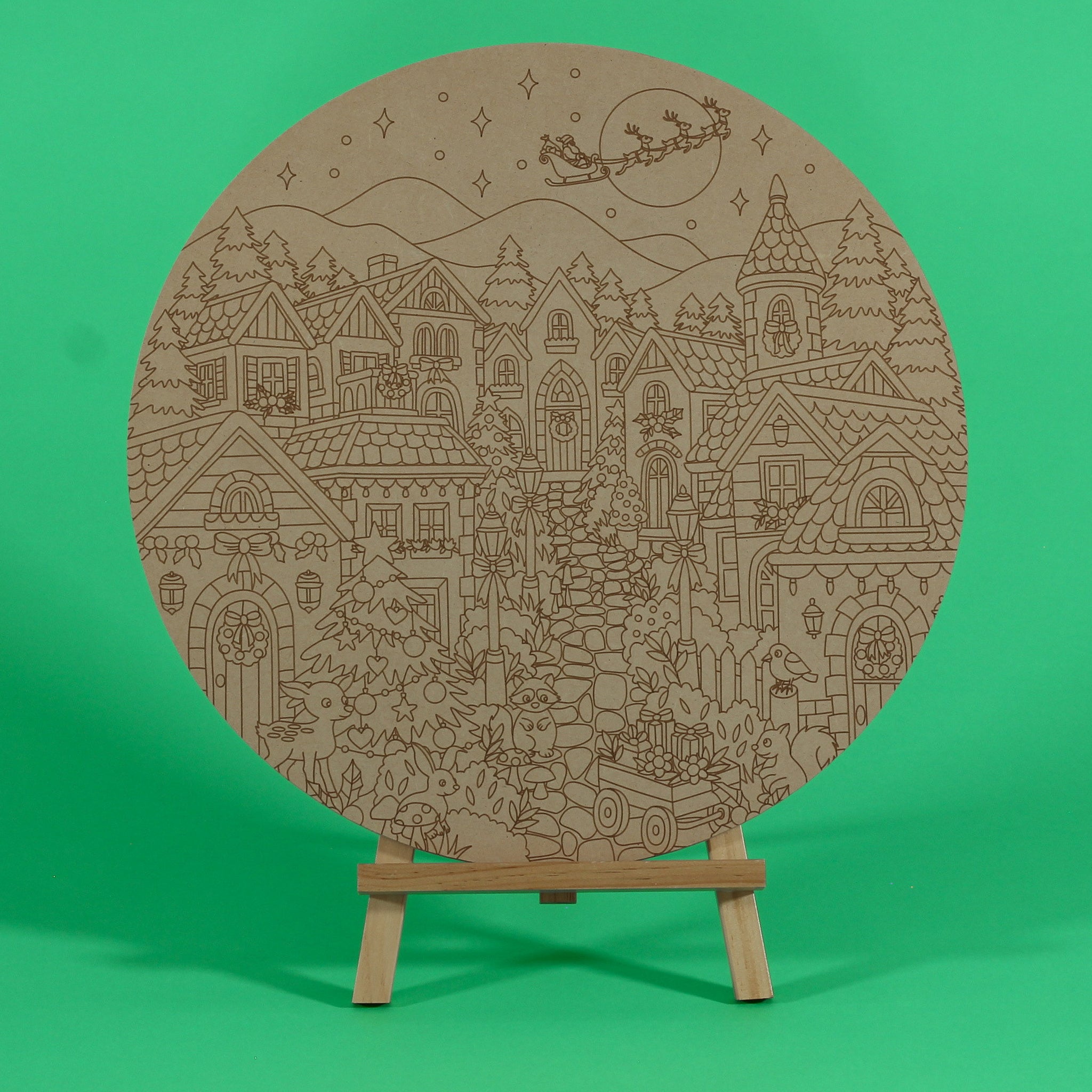 Mistletoe Lane Christmas village engraved circle art board to colour on an easel, with houses, Santa sleigh over the moon, reindeer and Christmas tree